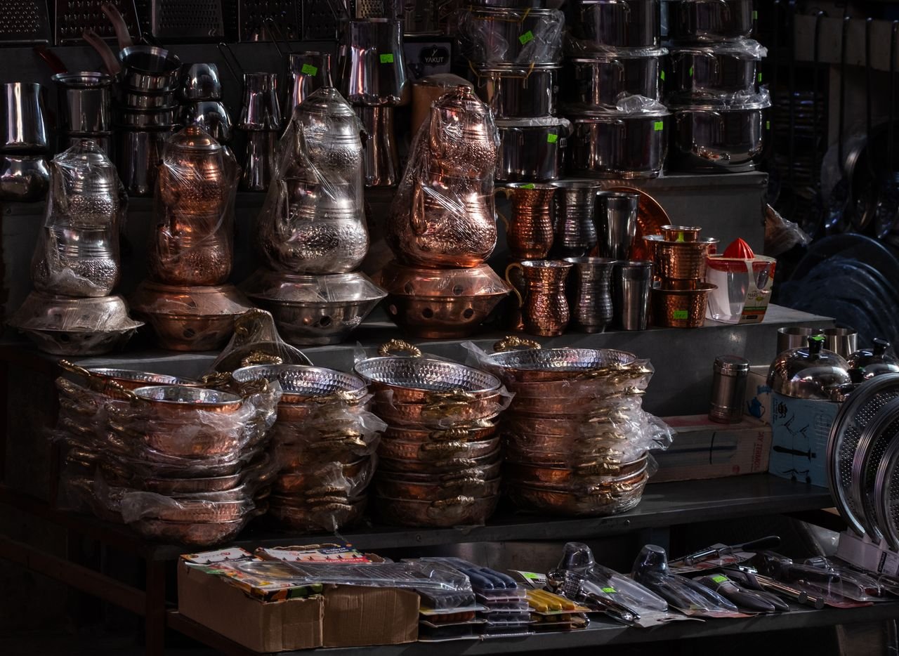 A vibrant display of traditional copper and metalware at a market stall in İzmir, Türkiye.